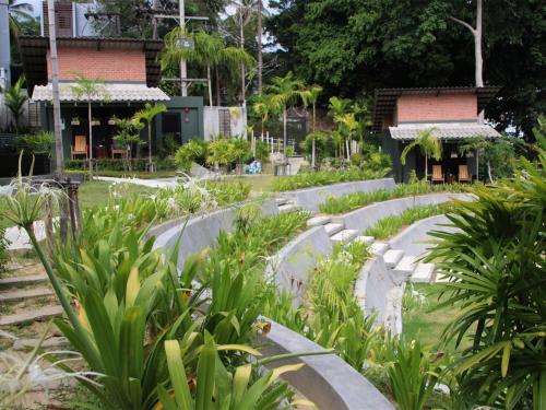 a garden with concrete steps and plants in front of buildings at Eco Inn Cottage by Aonang Hill in Ao Nang Beach
