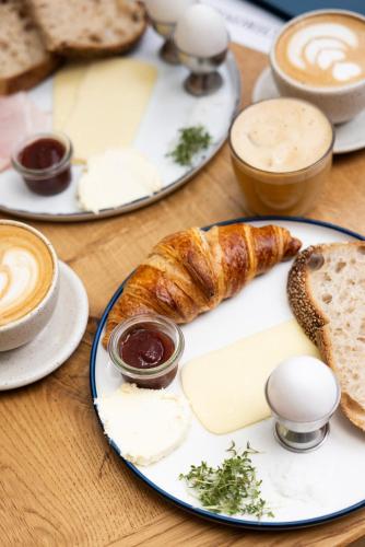 a table with plates of cheese and bread and coffee at Hotel Alexandra in Copenhagen