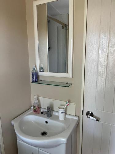 a bathroom with a sink and a mirror at Mobil Home avec WIFI -6-8 Personnes in Lattes