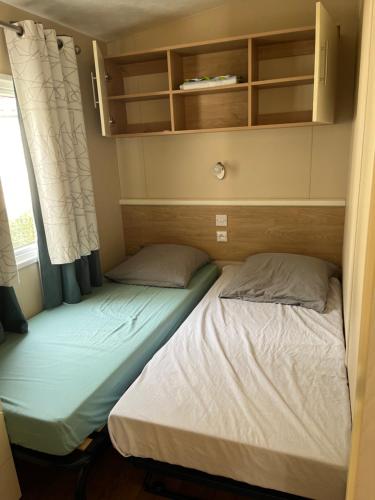 two beds in a small room with a window at Joelle et Patrick in Lattes