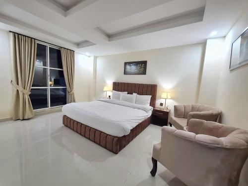 纳兰恩Iconic Hotel Naran的一间有一张大床和两把椅子的卧室