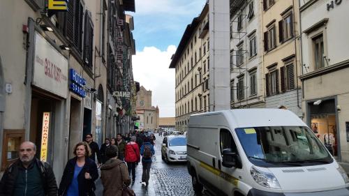 un grupo de personas caminando por una calle de la ciudad con una furgoneta en Il Gigliolo Apartment, en Florencia