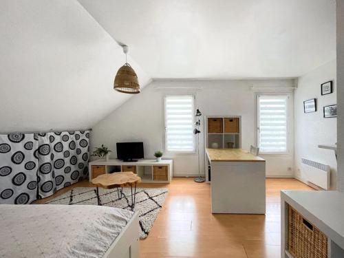 une pièce blanche avec une cuisine et un bureau avec un ordinateur dans l'établissement T1 cosy - 5min du port - parking - linge inclus, à Vannes