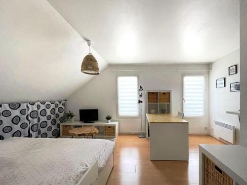 une chambre avec un lit et un bureau et une cuisine dans l'établissement T1 cosy - 5min du port - parking - linge inclus, à Vannes