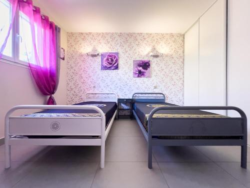 - 2 lits dans une chambre avec des rideaux roses dans l'établissement Grande maison moderne avec piscine 10 personnes, à Trouillas