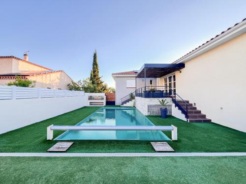 une cour avec une piscine et de l'herbe verte dans l'établissement Grande maison moderne avec piscine 10 personnes, à Trouillas