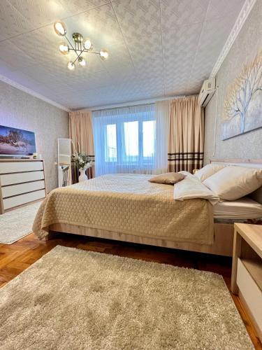 a bedroom with a large bed and a window at Центр Торговиця 1 кімнатні апартаменти in Ternopilʼ