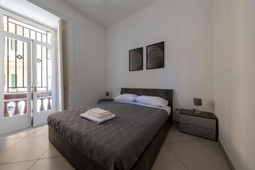 a bedroom with a bed and a large window at Casa Vacanze Nemesi TYCHE in Salerno