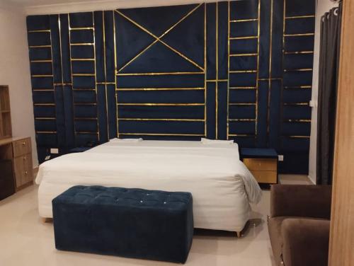 a bedroom with a bed with a black and gold wall at Dozubel Hotel in Abuja