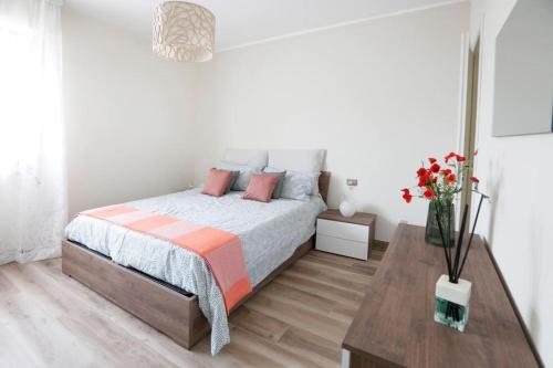 - une chambre blanche avec un lit et une table en bois dans l'établissement Valentine's Home, à Viareggio