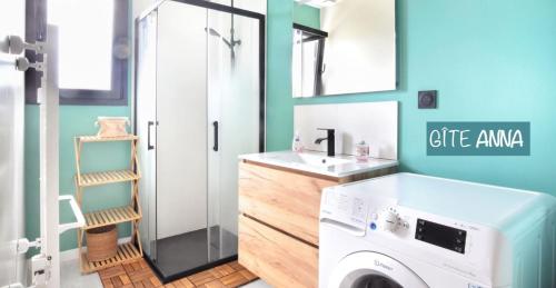 a bathroom with a washing machine and a sink at Gîtes Rozanna avec accès détente SPA JACUZZI in Saint-Jean-de-la-Rivière