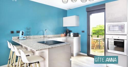 a kitchen with blue walls and a counter with chairs at Gîtes Rozanna avec accès détente SPA JACUZZI in Saint-Jean-de-la-Rivière
