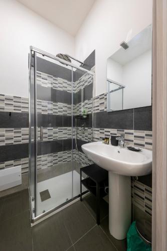 a bathroom with a sink and a glass shower at Casa Vacanze Nemesi TYCHE in Salerno