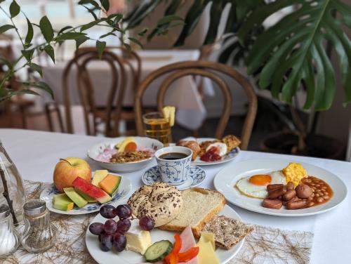 - une table avec des assiettes de petit-déjeuner dans l'établissement First Hotel Breiseth, à Lillehammer