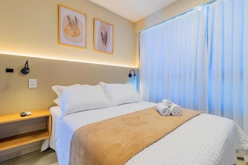 a bedroom with a bed and a window with blue curtains at Allure Residence by Carpediem in Recife