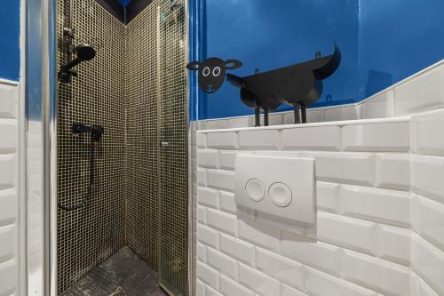 une salle de bain avec une douche avec une vache sur le mur dans l'établissement Par Amour, à Paris