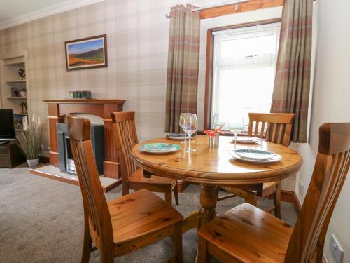 a dining room with a wooden table and chairs at The Cottage in Kirriemuir