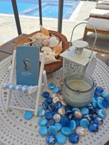 a table topped with a basket of shells and a bowl of water at Sarti Thea in Sarti