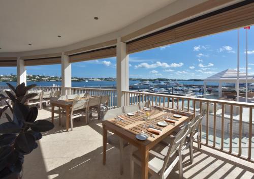 uma sala de jantar com mesas e cadeiras numa varanda em Hamilton Princess & Beach Club A Fairmont Managed Hotel em Hamilton