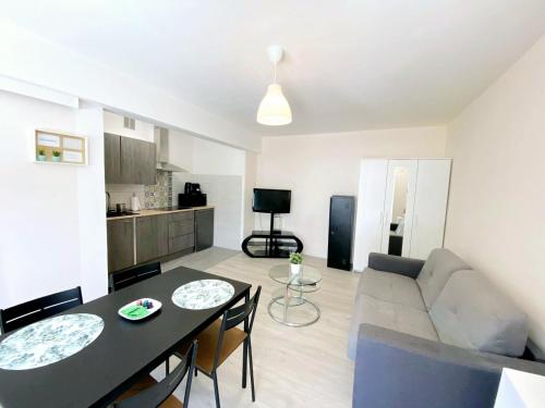 un salon avec un canapé et une table avec des chaises dans l'établissement BEL AIR - Studio, Proche centre, WIFI, Climatisation, à Antibes