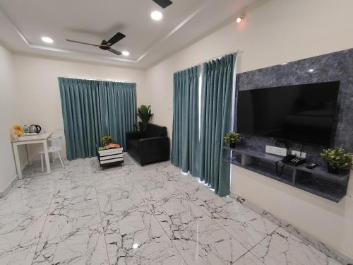 a living room with a flat screen tv and green curtains at Hotel Aerotel,Hyderabad in Shamshabad