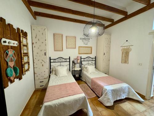 1 dormitorio con 2 camas y lámpara de araña en Vivienda Vacacional Ca'Má en Puerto del Rosario
