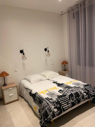 une chambre avec un lit et deux lampes au mur dans l'établissement VILLA OCEANE, à Cannes