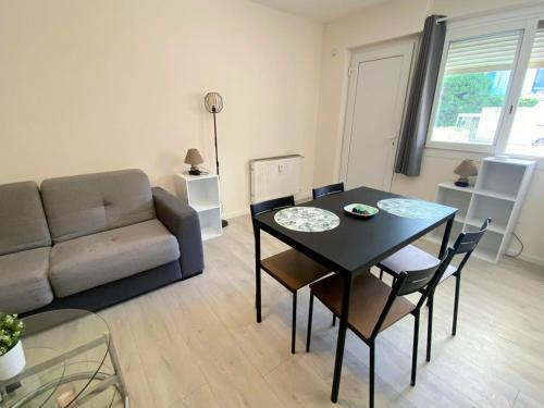 un salon avec une table et un canapé dans l'établissement BEL AIR - Studio, Proche centre, WIFI, Climatisation, à Antibes