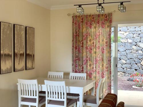 una sala da pranzo con tavolo, sedie e tenda di CHC - Tranquilidad Golf a Buenavista del Norte