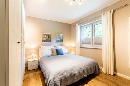 a bedroom with a bed and a window at Ferienhaus Beach House Scharbeutz in Scharbeutz