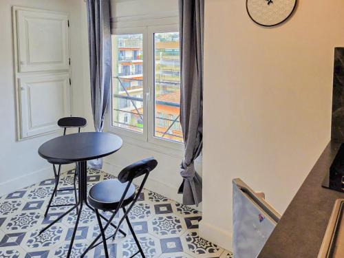 une chambre avec deux tabourets, une table et une fenêtre dans l'établissement Jean Medecin - AC, 2pers, Hyper center, à Nice