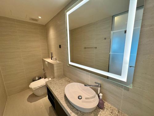 a bathroom with a sink and a toilet and a mirror at Star Residence Suite KLCC in Kuala Lumpur