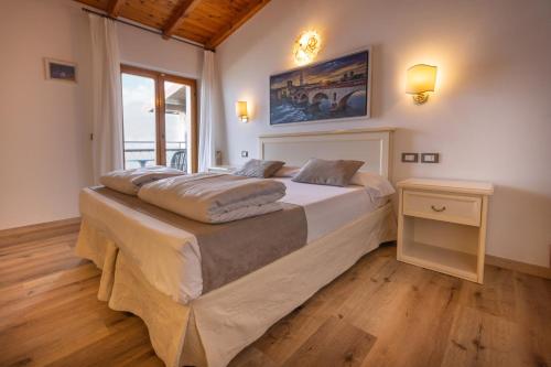 a bedroom with a large bed and a window at Hotel Rabay in Brenzone sul Garda