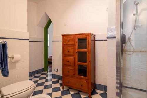 a bathroom with a toilet and a wooden cabinet at Argentarola in Porto Santo Stefano,Pool and Sea View in Porto Santo Stefano