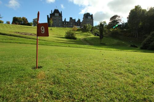a sign in the grass in front of a castle at The Atholl Palace in Pitlochry