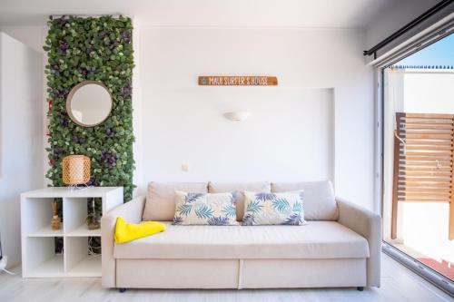 a living room with a couch and a green wall at Maui Surfer's House Sea view Caparica Beach House in Costa da Caparica