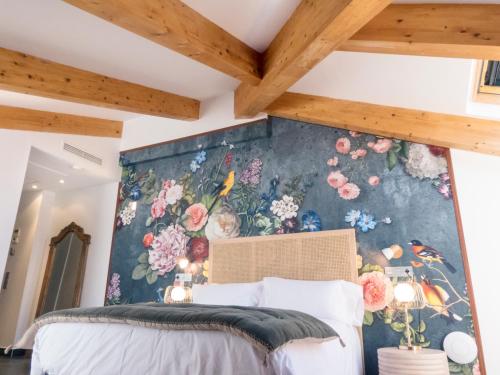 a bedroom with a floral mural on the wall at Christine Boutique Hotel in El Barraco