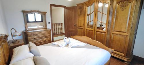 a bedroom with a large white bed and a wooden cabinet at VILLA DOLARETXE by Urdaibai Rentals in Bilbao