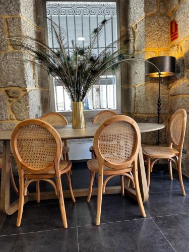 a table with chairs and a vase with a plant at Christine Boutique Hotel in El Barraco