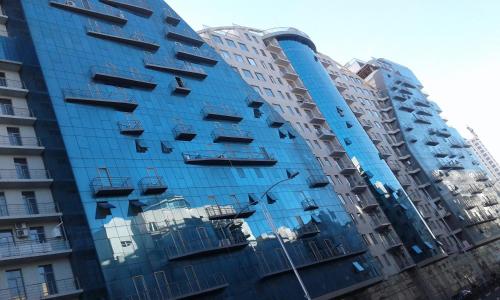 a blue building with balconies on the side of it at Apartment on Khimshiashvili 1 in Batumi