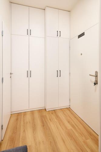 a room with four white closets and a wooden floor at Apartmán Jablone in Bytča