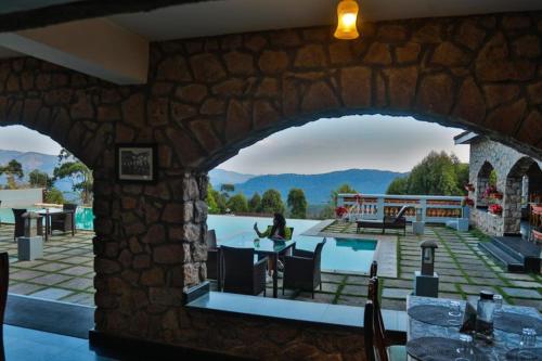 an archway in a stone building with a person sitting at a table at Mountain Club Resort Munnar in Chinnakanal
