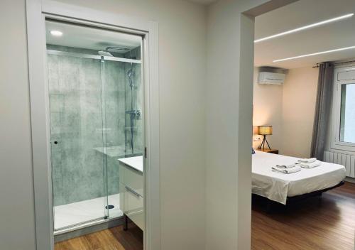 ein Bad mit einem Bett und einer Glasdusche in der Unterkunft Sweet BCN Laforja in Barcelona