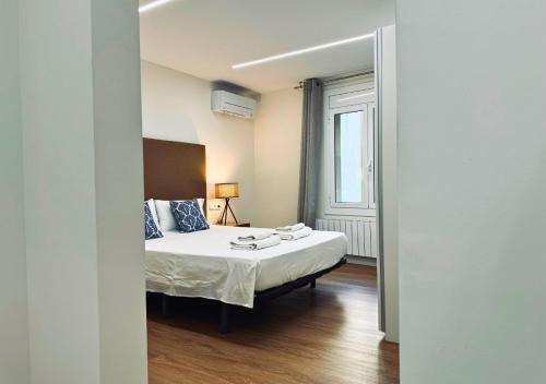 ein Schlafzimmer mit einem Bett und einem großen Fenster in der Unterkunft Sweet BCN Laforja in Barcelona