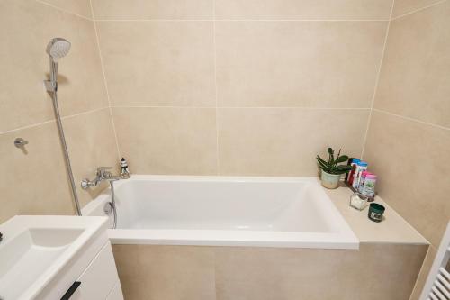 a bathroom with a white bath tub next to a sink at Apartmán Jablone in Bytča