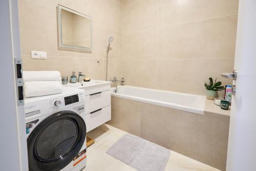 a bathroom with a washing machine and a sink at Apartmán Jablone in Bytča
