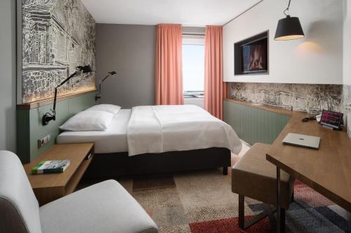 a hotel room with a bed and a desk at Hotel FREIZEIT IN in Göttingen