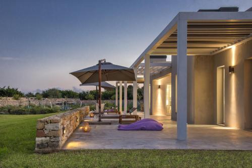 a patio with a table and an umbrella at Casa Faro Favignana in Favignana