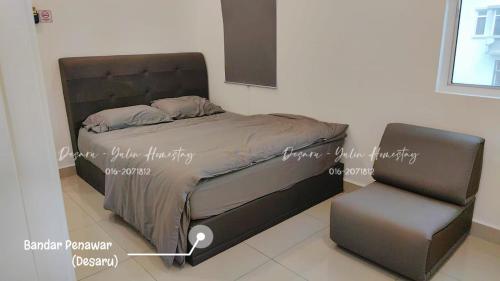 a bed and a chair in a room at Desaru Yulin Homestay 雨林客棧Desaru, Bandar Penawar in Bandar Penawar