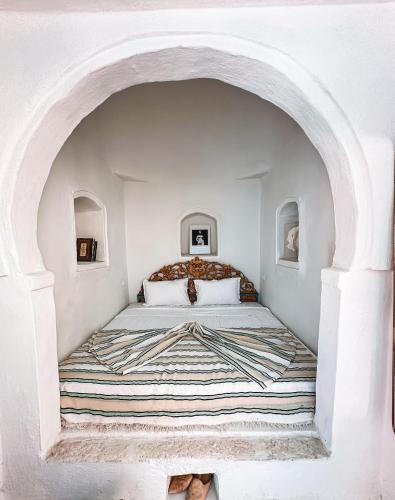 a bedroom with a bed in a white room at Dar Fen Luxery House in Houmt Souk